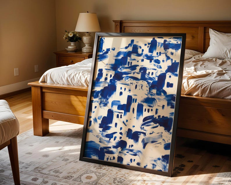 a large blue and white abstract painting displayed on a wooden bed frame in a bedroom setting.