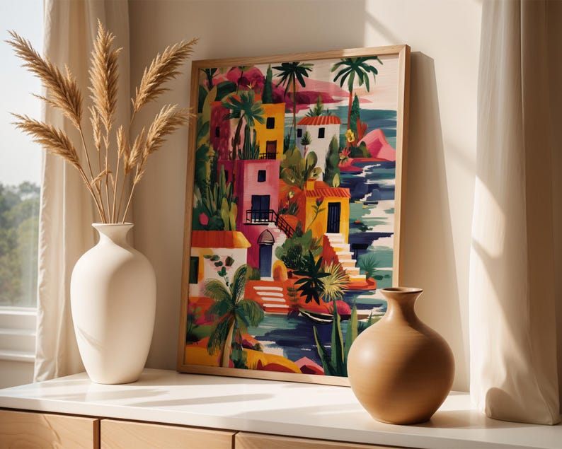 a vibrant painting of a tropical island scene, with colorful buildings, palm trees, and a body of water. The painting is framed and displayed on a shelf, accompanied by two white vases and a wooden sculpture.
