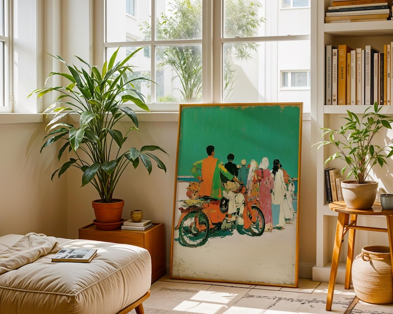 a living room with a large painting of a group of people on a motorcycle, a potted plant, a bookshelf, and a footrest.