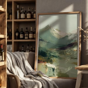 a cozy living room with a large framed landscape painting hanging on the wall, a wooden bookshelf filled with various bottles, and a comfortable couch with a gray blanket draped over it.