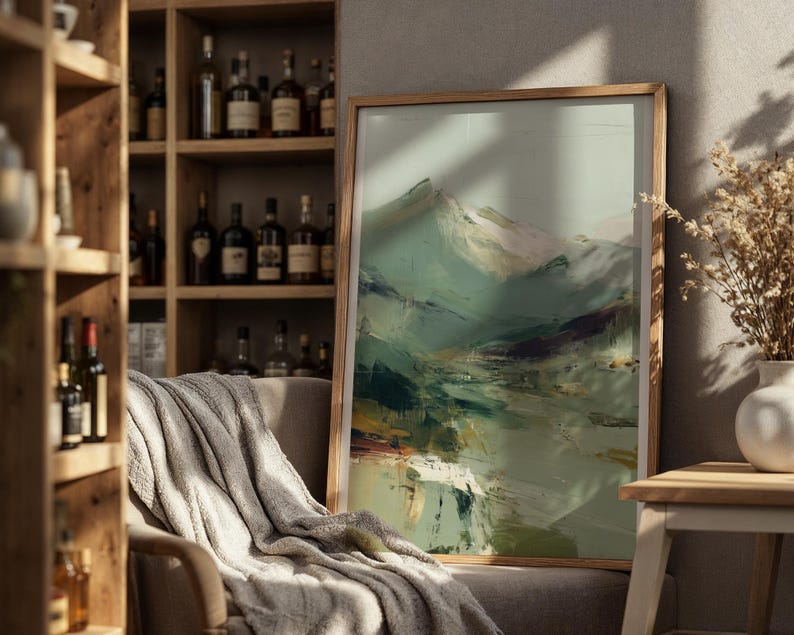 a cozy living room with a large framed landscape painting hanging on the wall, a wooden bookshelf filled with various bottles, and a comfortable couch with a gray blanket draped over it.
