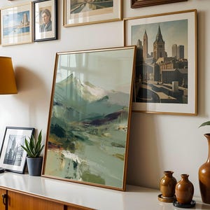 a wall adorned with framed pictures and a large abstract painting, creating a visually appealing display.