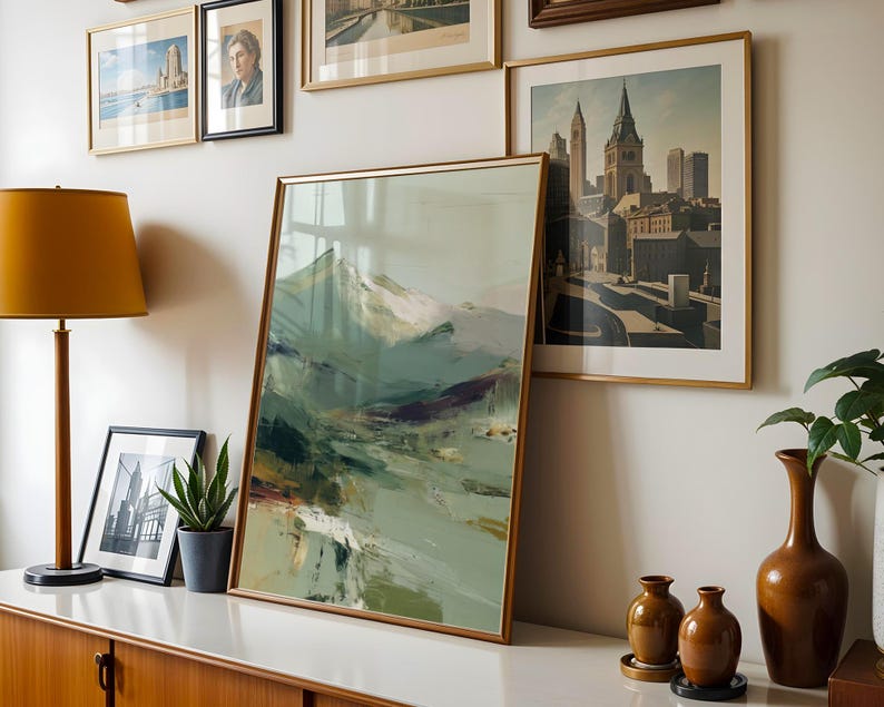 a wall adorned with framed pictures and a large abstract painting, creating a visually appealing display.