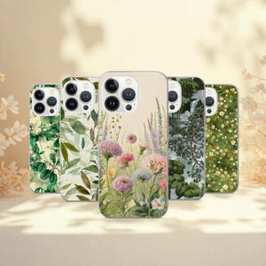 May include: Five phone cases with floral designs. The cases feature various botanical patterns, including green leaves, colorful wildflowers, and a serene landscape with a waterfall. The cases have a glossy finish and are arranged in a row.