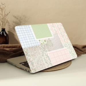 Può includere: Un computer portatile con una pellicola protettiva dal design patchwork con vari motivi tra cui quadretti vichy azzurri, pois verdi, strisce floreali rosa e tartan. Il design presenta bordi simili a pizzo bianco e un ritaglio per il logo Apple.