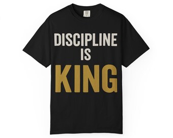 May include: Black t-shirt with the text "DISCIPLINE IS KING" in white and gold lettering. The shirt has short sleeves and a crew neck. The design is centered on the front of the shirt.