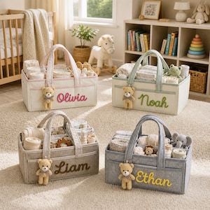Peut inclure: Quatre paniers de rangement rectangulaires en tissu pour chambre d'enfant avec poignées et séparateurs internes. Chaque panier comporte une peluche ours et des prénoms brodés : Olivia en rose, Noah en vert, Liam en marron et Ethan en jaune.