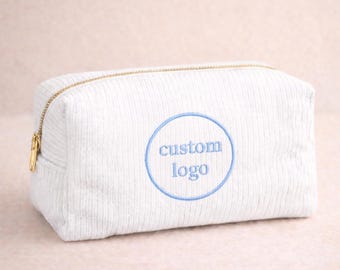 Nécessaire de maquiagem em veludo cotelê personalizada com logotipo bordado, ideal para eventos corporativos, brindes para equipes e organização de cosméticos. Perfeita para viagens e eventos.