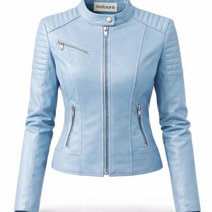 May include: Light blue jacket with a stand-up collar and a zipper closure. The jacket has quilted detailing on the shoulders and sleeves, and multiple zippered pockets. The brand name "Veloura" is visible on the collar.