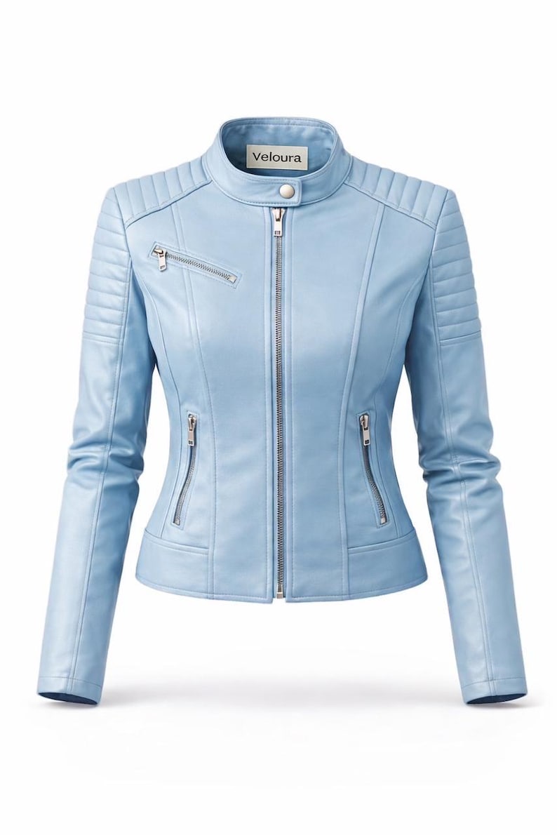 May include: Light blue jacket with a stand-up collar and a zipper closure. The jacket has quilted detailing on the shoulders and sleeves, and multiple zippered pockets. The brand name "Veloura" is visible on the collar.