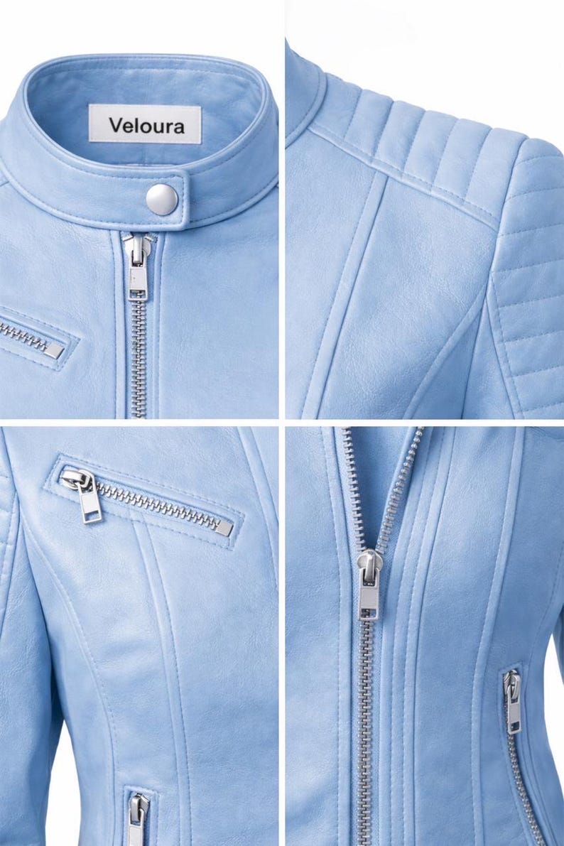 May include: Close-up of a light blue jacket with a stand-up collar and silver zipper. The jacket has quilted shoulder details and a small pocket with a zipper. The brand name "Veloura" is visible on a tag.