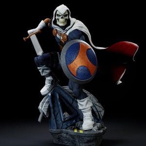 May include: A detailed figurine of a character in a white hooded cloak and skull mask, holding a sword and shield. The shield is blue and orange. The figure is posed on a stone base, with a red cape flowing behind it. The character is wearing a blue and white suit.