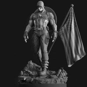 Può includere: Statua in scala di grigi di Captain America, con bandiera americana. La figura indossa un costume dettagliato con un'emblema a stella e un elmetto. La bandiera è drappeggiata e la statua è su una base rocciosa. Espressione seria.