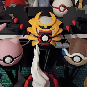 Op de afbeelding: Een verzameling kleurrijke, gestileerde figuren die lijken op personages uit een populaire animatieserie. De figuren omvatten een roze bol met een gezicht, een geel en rood figuur in samurai-stijl en een bruin schildpadachtig figuur, allemaal met ingewikkelde details.