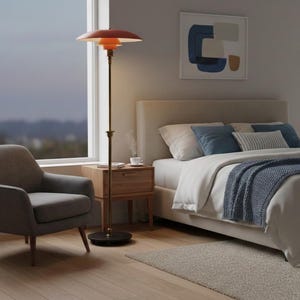 Puede incluir: Un dormitorio moderno con una l&aacute;mpara de pie con pantalla roja, un sill&oacute;n gris y una cama con almohadas y una manta azules. La l&aacute;mpara tiene un poste de lat&oacute;n y una base redonda. Una mesita de noche de madera y una obra de arte abstracta enmarcada completan la decoraci&oacute;n.