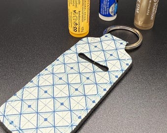 Llavero de neopreno con diseño geométrico azul para bálsamo labial