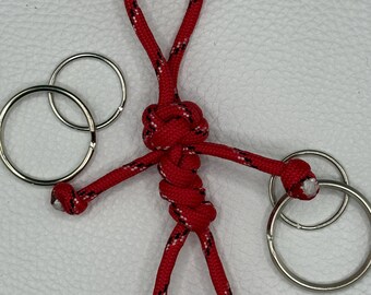 Llavero Buddy de paracord hecho a mano - Tirador de cremallera táctico rojo y negro - Adorno para bolso con forma de persona de paracord