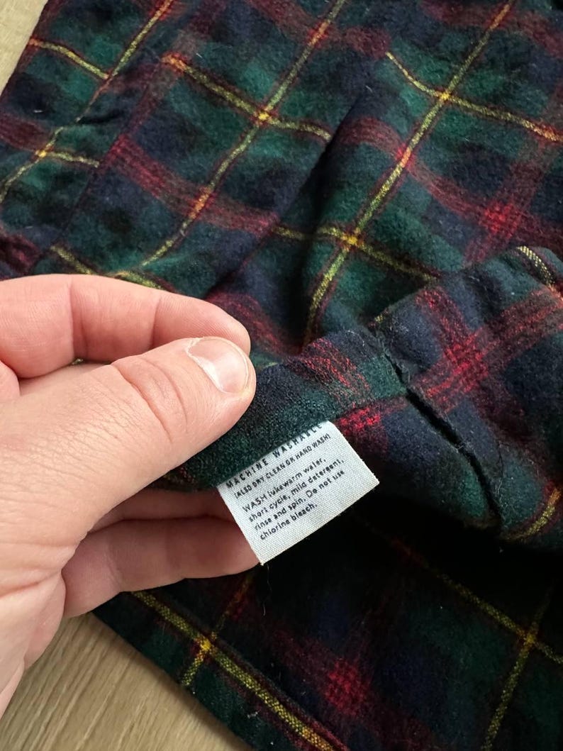 May include: A white ceramic mug with a black handle and the text "But First, Coffee" in a black, handwritten-style font. The mug is on a white surface.