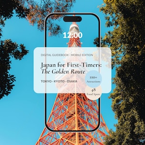 以下が含まれることがあります： スマートフォン画面に「Japan for First-Timers: The Golden Route」と題されたデジタルガイドブックが表示されています。画像は東京タワーを示しています。ガイドブックは観光名所と飲食店を強調しています。
