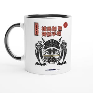May include: White ceramic mug with a black interior and handle. The mug features a detailed black and gray graphic design with Japanese text and red accents. A unique and stylish drinkware item.