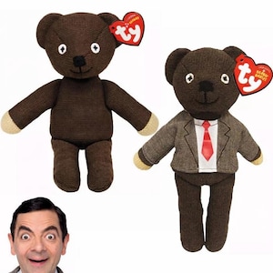 Può includere: Due orsacchiotti marroni, uno con giacca e cravatta, l'altro semplice. Entrambi hanno occhi bianchi e zampe beige. Ogni orso ha un'etichetta rossa a forma di cuore. Un uomo con espressione sorpresa è in basso a sinistra.