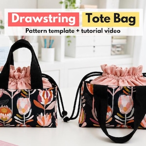 Può includere: Due borse tote con chiusura a coulisse, base in tessuto nero e un motivo floreale colorato con fiori rosa, arancioni e bianchi. Ogni borsa ha manici neri e una chiusura a coulisse in tessuto rosa. Il testo recita: Drawstring Tote Bag Pattern template + tutorial video.