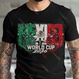 May include: A black short-sleeve t-shirt featuring a graphic print with the text MEXICO WORLD CUP 2026. The design incorporates the colors of the Mexican flag, images of soccer players, the national emblem, and a soccer ball illustration.