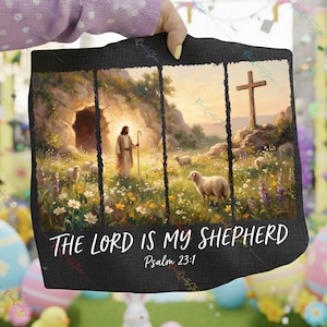 May include: Black decorative wall hanging featuring a pastoral scene with Jesus, sheep, and a cross. The text "THE LORD IS MY SHEPHERD" and "Psalm 23:1" are displayed in white script. The artwork is framed by a dark border.