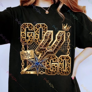 May include: Black t-shirt with a gold and leopard print design. The design includes the words "GO GO GO", a crown, a star, and a lightning bolt. The shirt has a crew neck and short sleeves.