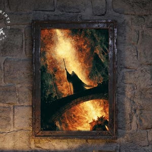 May include: Framed artwork depicting a silhouetted figure on a bridge, holding a staff, against a fiery background. The artwork is in a rustic, dark brown frame. The image is mounted on a textured stone wall. The artwork is from Ashen Prints Shop.