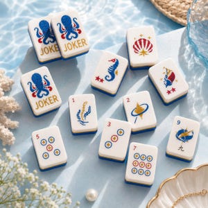 May include: A collection of white and blue Mahjong tiles with various illustrations, including an octopus, seahorse, and shell. Some tiles display numbers and symbols. The tiles are arranged on a light blue surface, with the word "JOKER" visible on some.