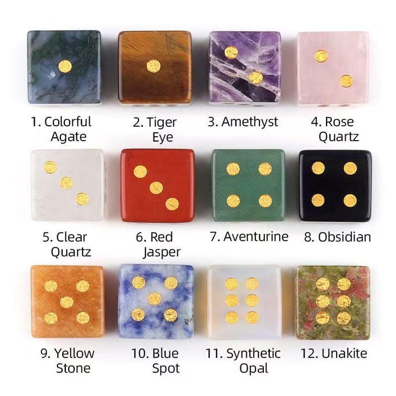 May include: A collection of twelve square dice made from various gemstones, each with gold-colored dots. The dice are labeled with the names of the stones, including Colorful Agate, Tiger Eye, Amethyst, Rose Quartz, Clear Quartz, Red Jasper, Aventurine, Obsidian, Yellow Stone, Blue Spot, Synthetic Opal, and Unakite.