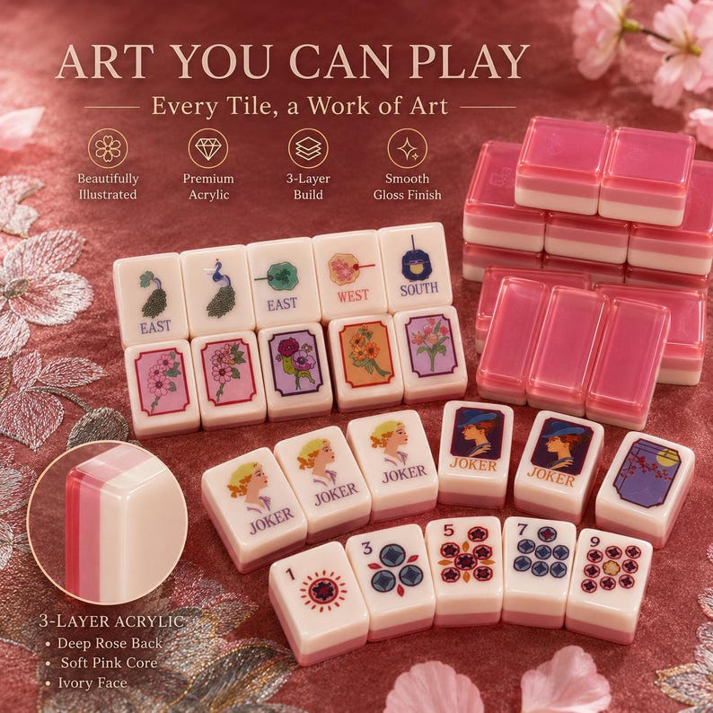 May include: A set of Mahjong tiles with a 3-layer acrylic design. The tiles feature illustrations and text, including "EAST", "WEST", "SOUTH", and "JOKER". The set includes pink and white tiles with a smooth gloss finish. The text "ART YOU CAN PLAY" is also visible.