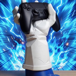 Può includere: Un controller di gioco nero tenuto da un supporto decorativo a forma di mano bianco e blu. Il supporto ha una parte superiore bianca e una base blu. Lo sfondo presenta un design a fulmini blu e bianchi.