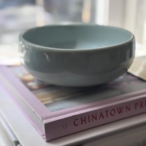 May include: A set of three ceramic mugs with a speckled, matte finish. The mugs are in shades of cream, light gray, and dark gray. Each mug has a simple, minimalist design, perfect for coffee or tea.