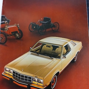 May include: A 1977 Ford Annual Report, showcasing a gold car with a black grille and cream interior. The cover also features two antique cars and the Ford logo, set against a red background.