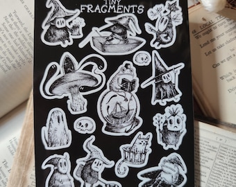 May include: A black sheet of stickers with a white border featuring various illustrations of whimsical creatures and characters. The stickers are on a black background and include a frog, a cat, a ghost, a mushroom, a skull, and a variety of other creatures. The text "Tiny Fragments" is at the top of the sheet. The text "@thisison turner" is at the bottom of the sheet.