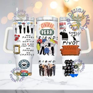 May include: Three white tumblers with designs from the TV show "Friends." One has the Central Perk logo, another features character illustrations, and the third includes phrases like "Pivot" and "Smelly Cat."