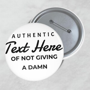 May include: White button with the text "AUTHENTIC Text Here OF NOT GIVING A DAMN" in black. The button has a metal pin back and a silver rim. The button is round.