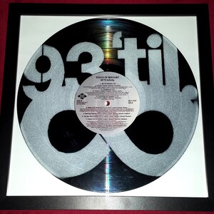 May include: Framed vinyl record featuring the words "93 til" in a silver, stencil-like design. The record label reads "Souls of Mischief" and "93 'Til Infinity." The frame is black with a white mat.