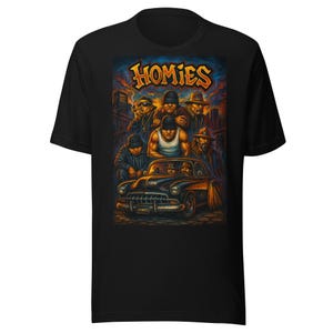 May include: Black t-shirt featuring a colorful graphic of a group of people, a classic car, and the word "Homies" in yellow and orange. The artwork has a stylized, urban theme with a sunset backdrop.