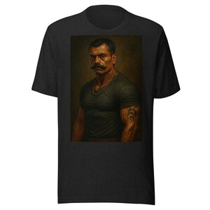 May include: Dark gray t-shirt featuring a portrait of a man with a mustache, tattoos, and a gold chain. The portrait is set against a dark background. The t-shirt is made of a soft, comfortable material.