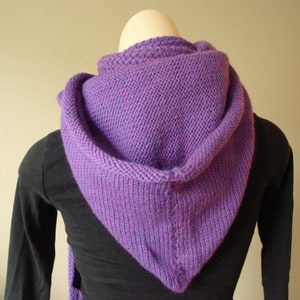 Puede incluir: Una capucha de punto de color morado con capucha. La capucha está hecha de un hilo suave y texturizado y tiene un diseño simple y elegante.