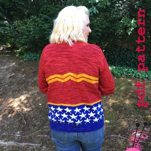 Op de afbeelding: Een rode, blauwe en gele gebreide trui met een wit sterrenpatroon. De trui heeft een Wonder Woman-logo op de rug.