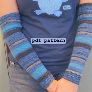 Puede incluir: Una persona lleva una camisa azul con un gráfico de un oso y el texto "Bigfoot" en ella. La persona también lleva calentadores de brazos a rayas azules y grises. El texto "pdf pattern" es visible en la camisa.