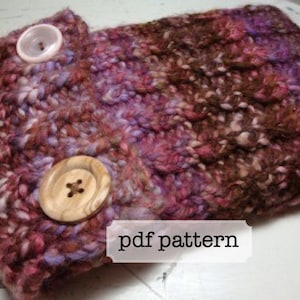 Puede incluir: Primer plano de un gorro de punto en tonos rosa, morado y marrón. El gorro tiene dos botones de madera y una etiqueta que dice "pdf pattern".