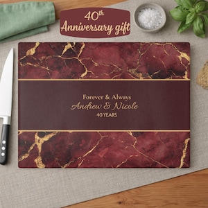 May include: A rectangular cutting board with a burgundy marble design and gold veining. The board has a dark burgundy band with the text "Forever & Always Andrew & Nicole 40 YEARS". The top of the board has the text "40th Anniversary gift".