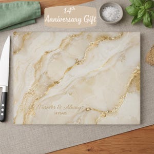 May include: A rectangular glass cutting board featuring a cream and beige faux marble pattern with gold veining. The text Forever & Always 14 YEARS is printed in a script and sans-serif font on the lower centre of the surface.