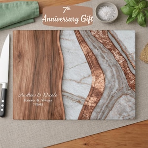 May include: A rectangular cutting board featuring a split design with a dark wood grain section on the left and a white marble pattern with copper-colored veins on the right. The text reads Andrew & Nicole, Forever & Always, 7 YEARS.