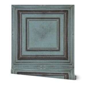 May include: A roll of wallpaper featuring a distressed, square panel design. The wallpaper has a teal and brown color scheme, with a layered, framed appearance. The design is reminiscent of aged wood paneling, adding a vintage aesthetic.